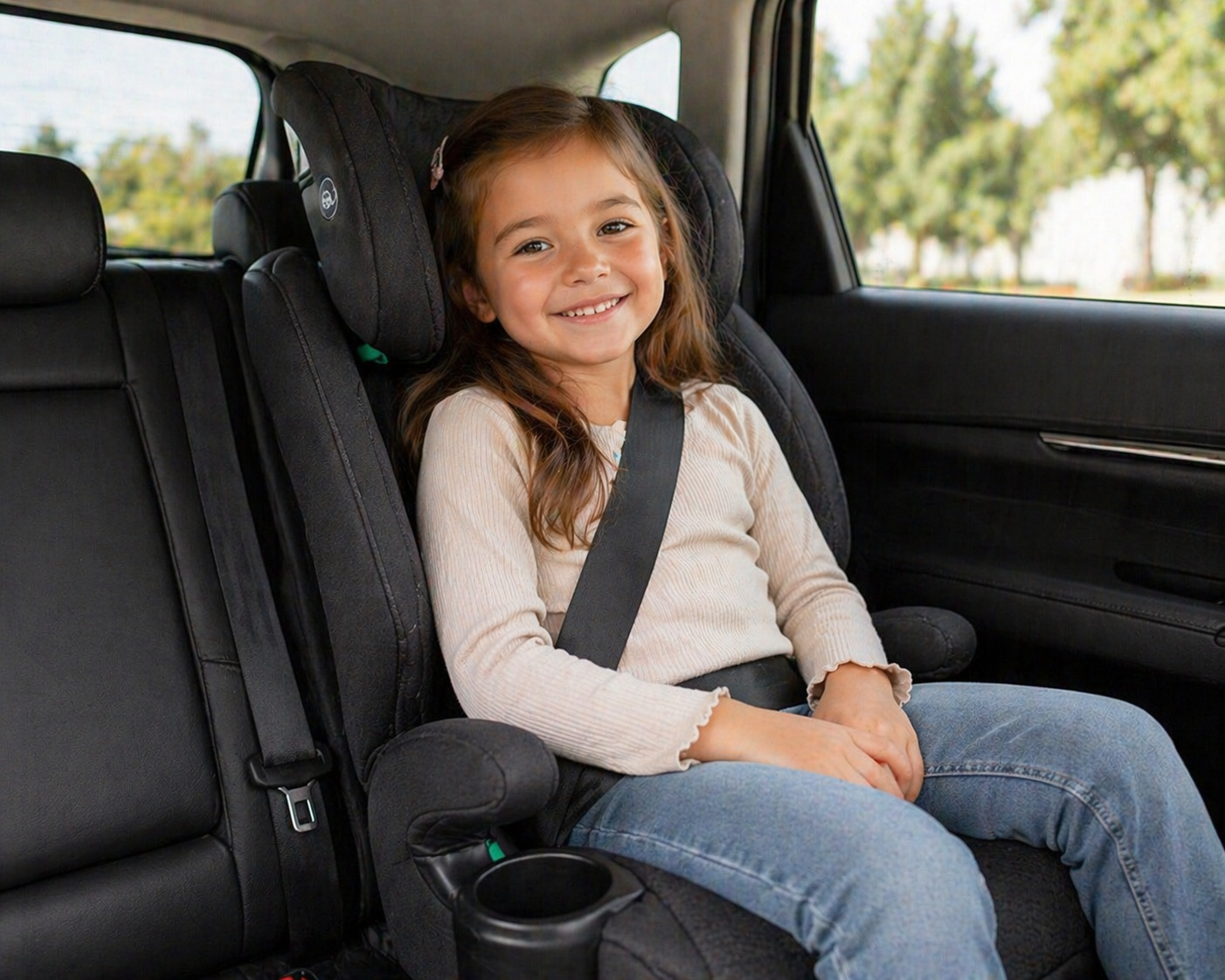 Child car seat collection featuring an older child seated in a high-back booster seat with a seatbelt fastened inside a modern car interior