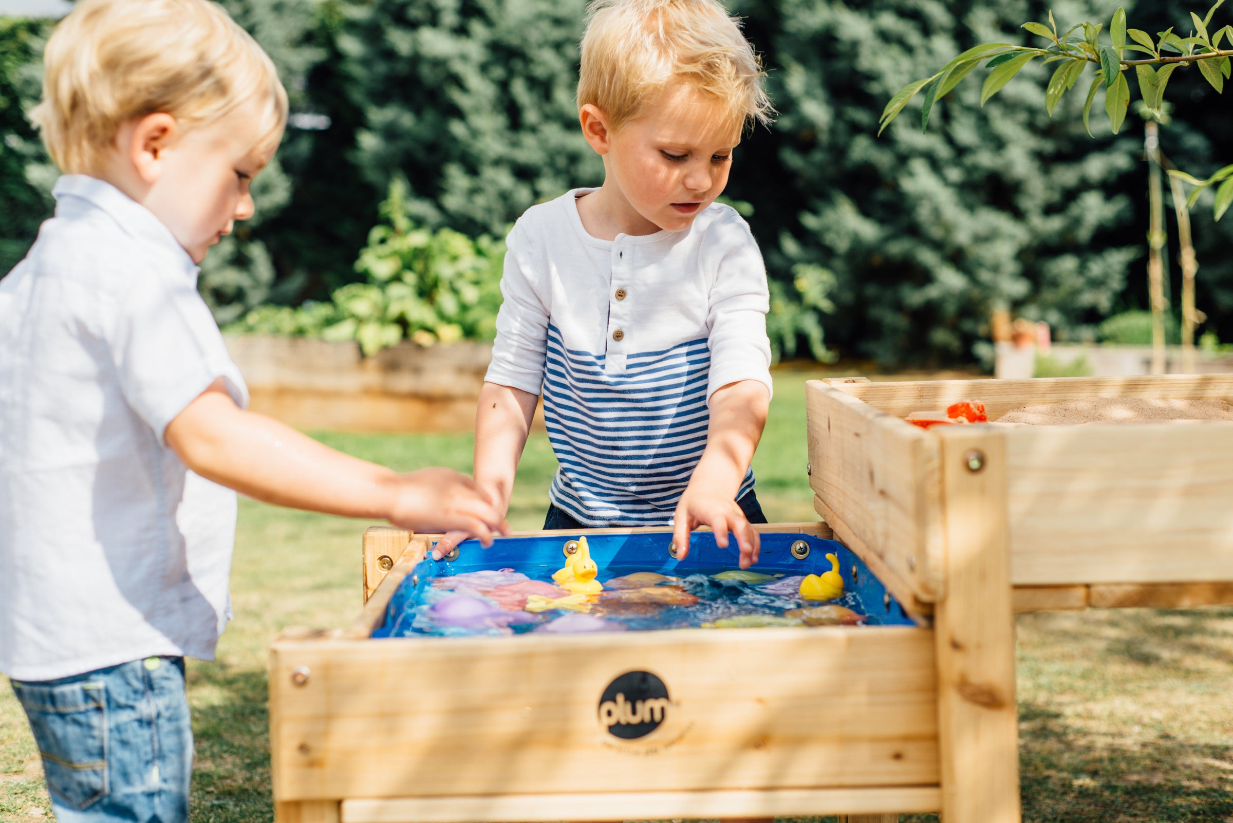 Plum sandpits and water play tables in garden for kids outdoor sensory play