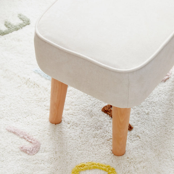 Cream stool with wooden legs on a light-coloured carpet