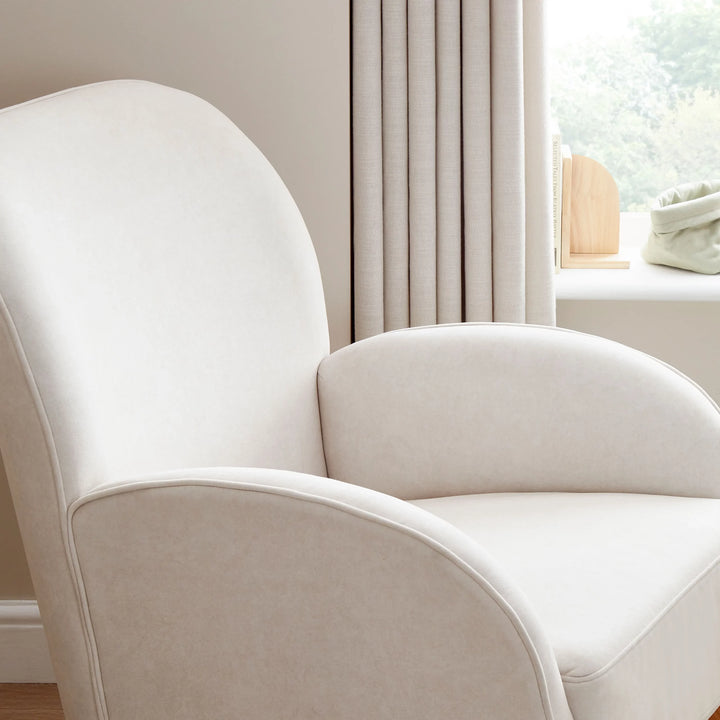Cream armchair in a room with light-coloured walls and a window.