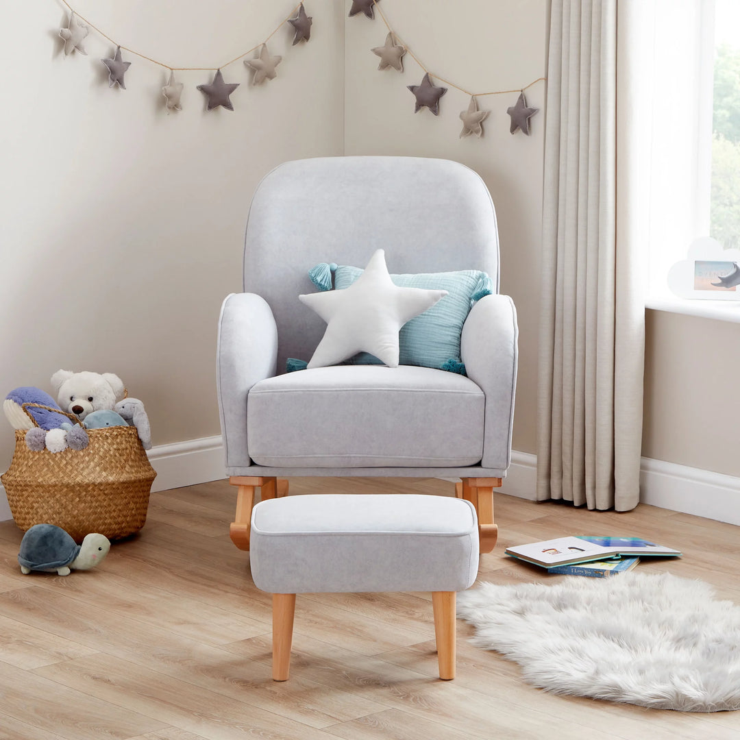 Grey armchair with a star-shaped pillow in a child-friendly room with toys and a basket.