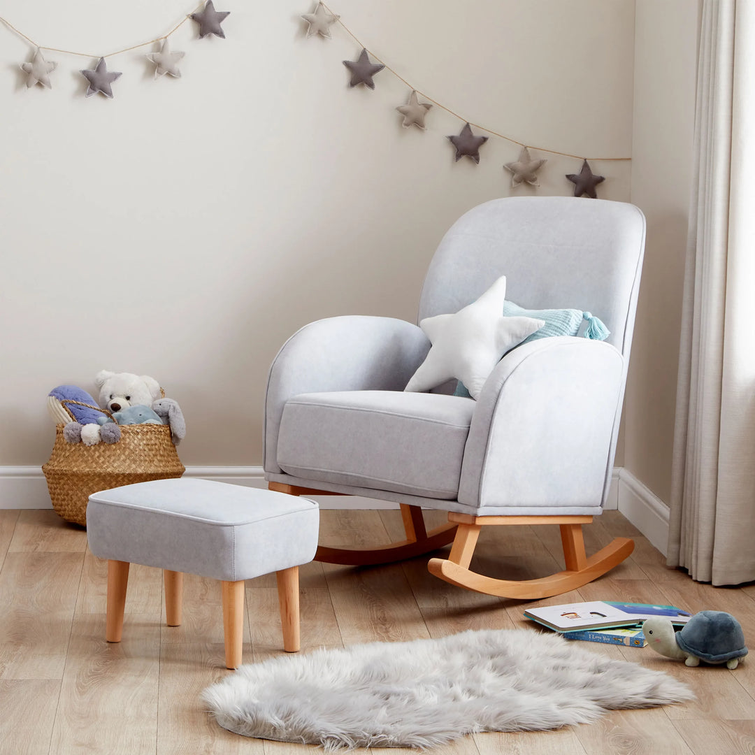Grey rocking chair with ottoman in a nursery setting with toys and decorations.