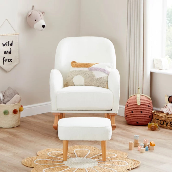 White armchair with a matching ottoman in a child's playroom with toys and decor.