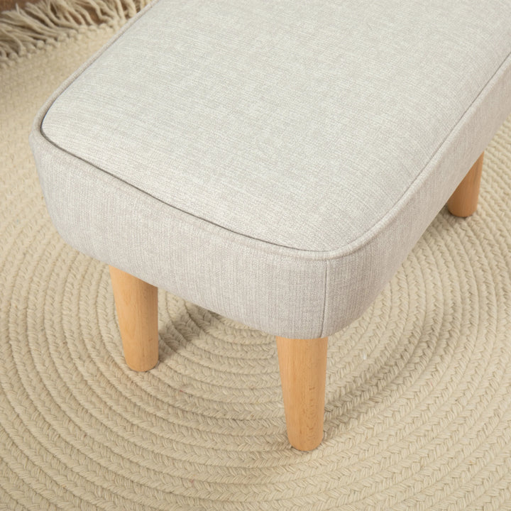 Cashmere upholstered stool with wooden legs on a textured beige surface