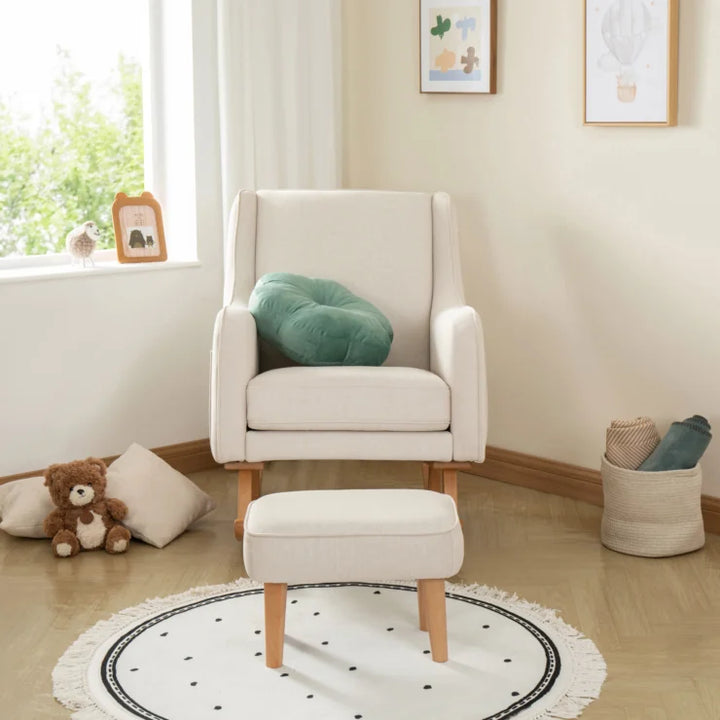 Ivory armchair with a green cushion in a room with a teddy bear and round rug.