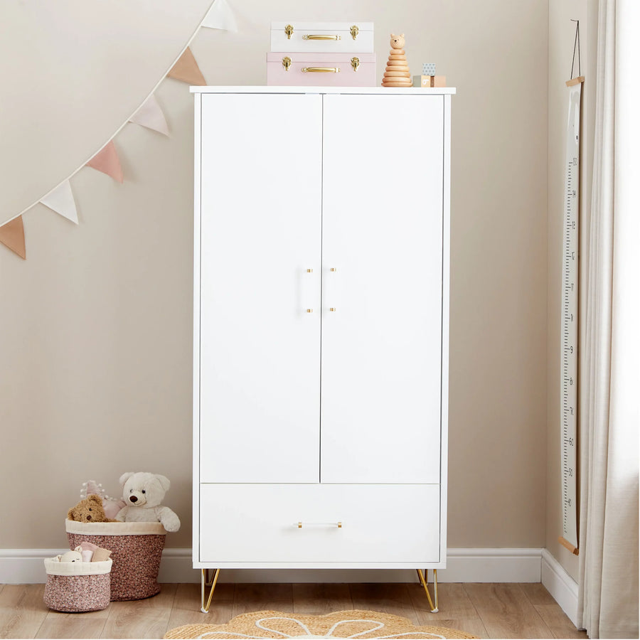White wardrobe in a child's room with toys and a measuring chart on a beige wall.