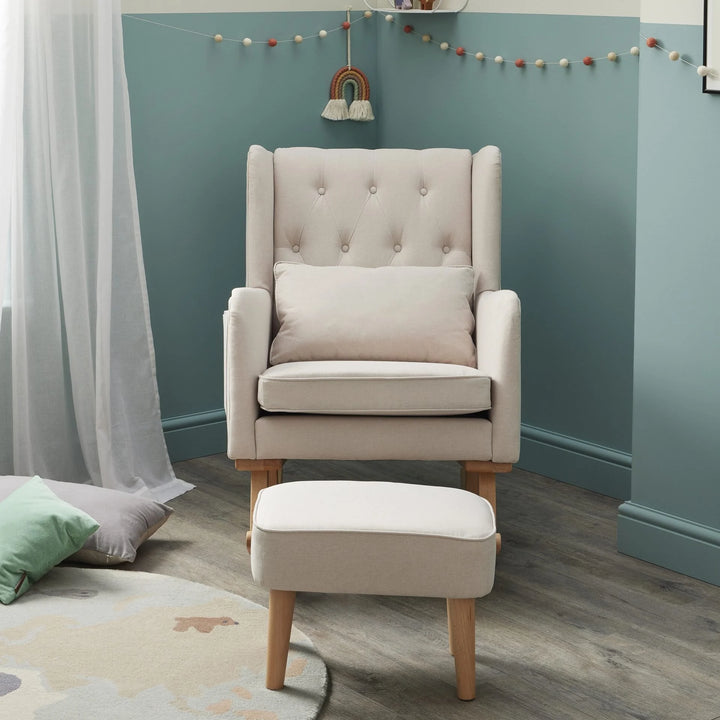 Beige armchair with ottoman in a room with teal walls and decorative string lights.