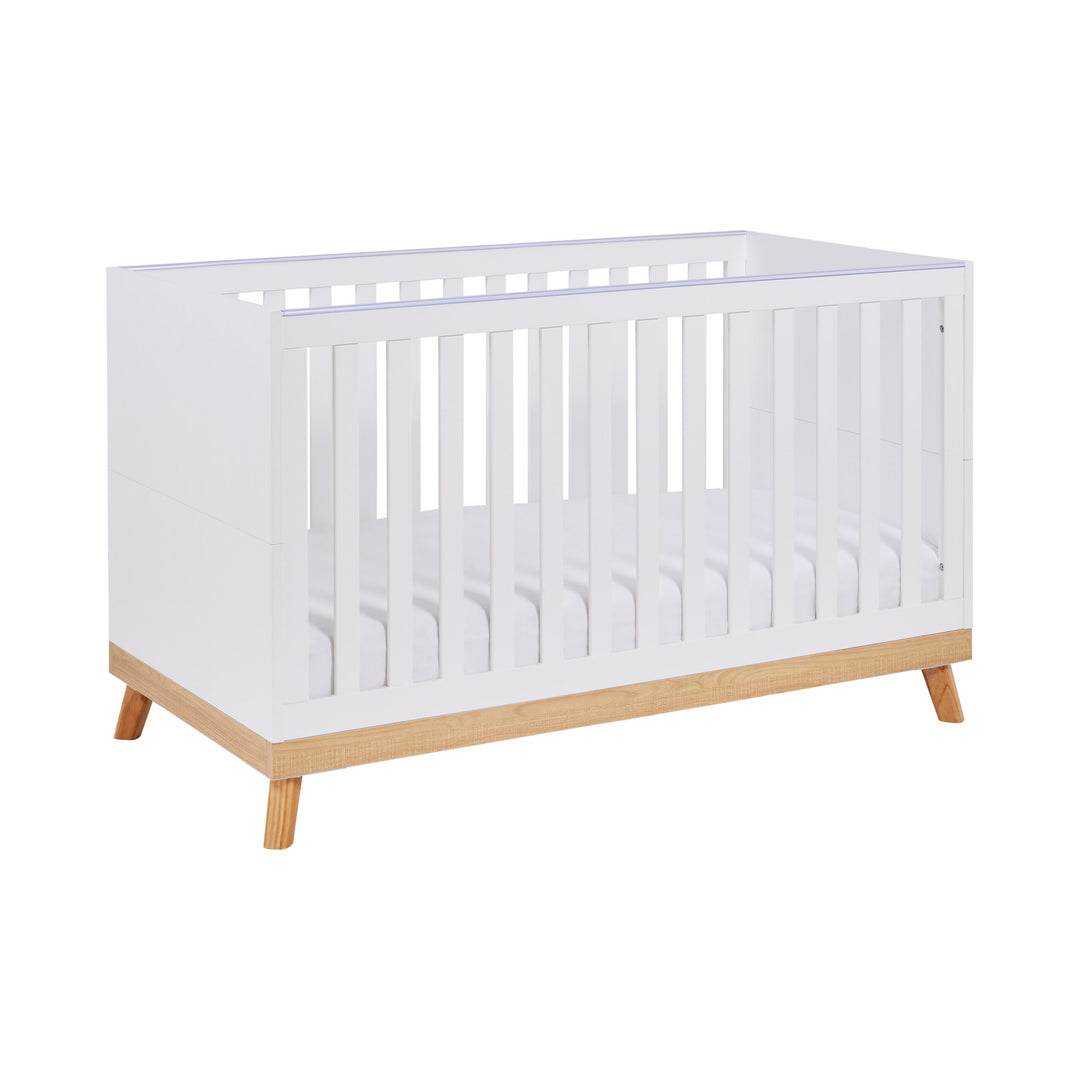 White crib with wooden legs on a white background