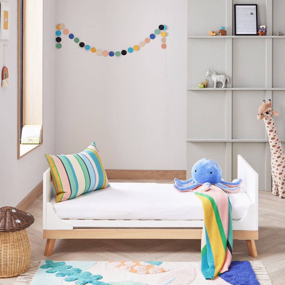Children's room with a toddler bed, colourful pillow, and plush octopus toy.