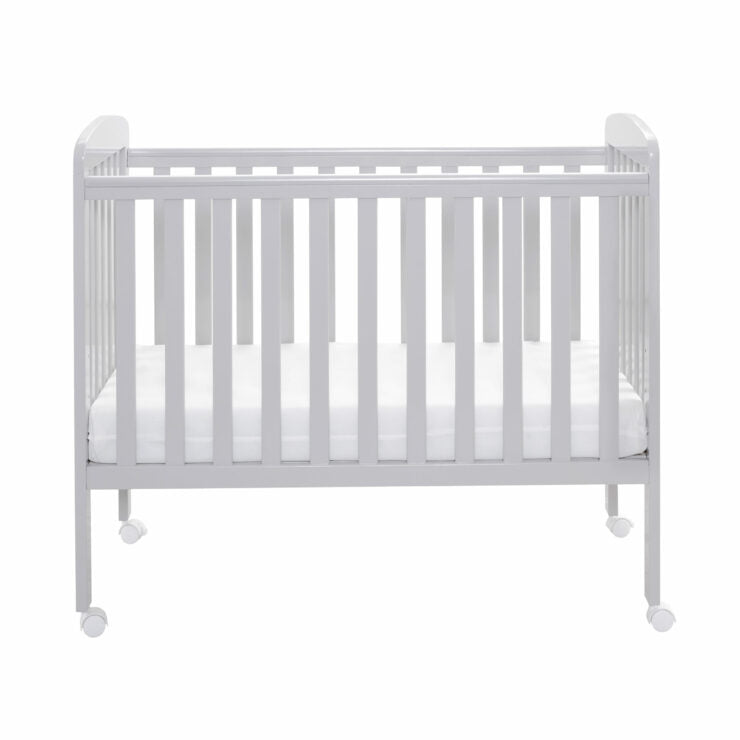 Grey crib with mattress on a white background