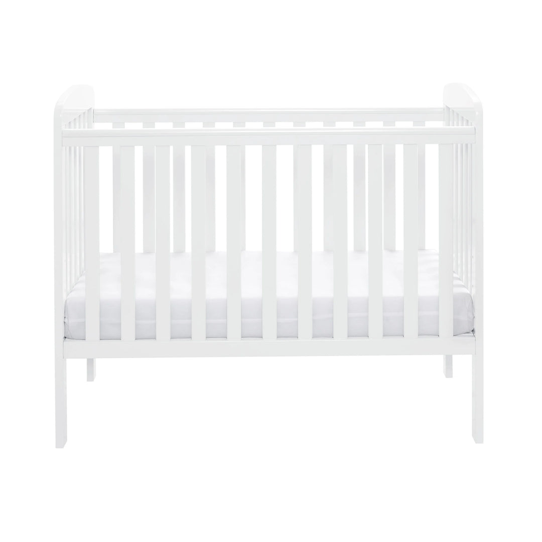 White crib with a white mattress on a white background