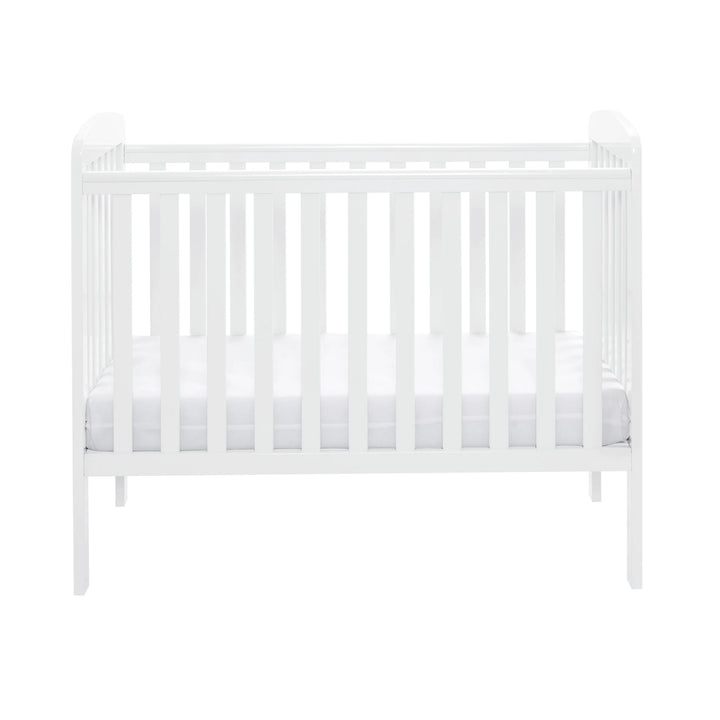 White crib with a white mattress on a white background