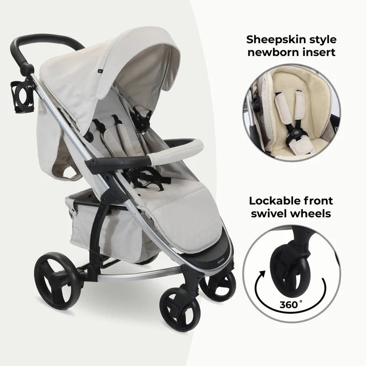 My babiie MB200i 3 in 1 travel system in oatmeal with sheepskin style newborn insert and lockable front swivel wheels on a white background.