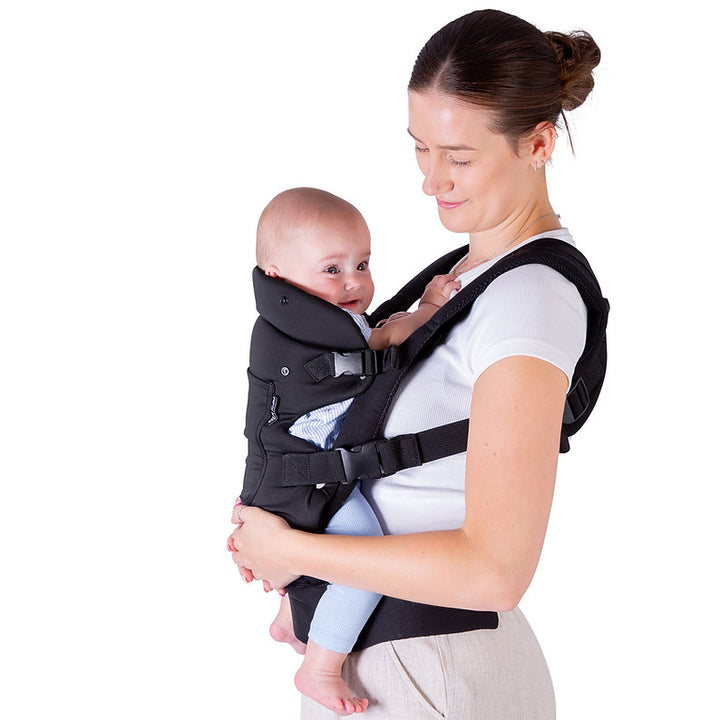 Woman carrying a baby in a Red Kite Ara baby carrier against a white background
