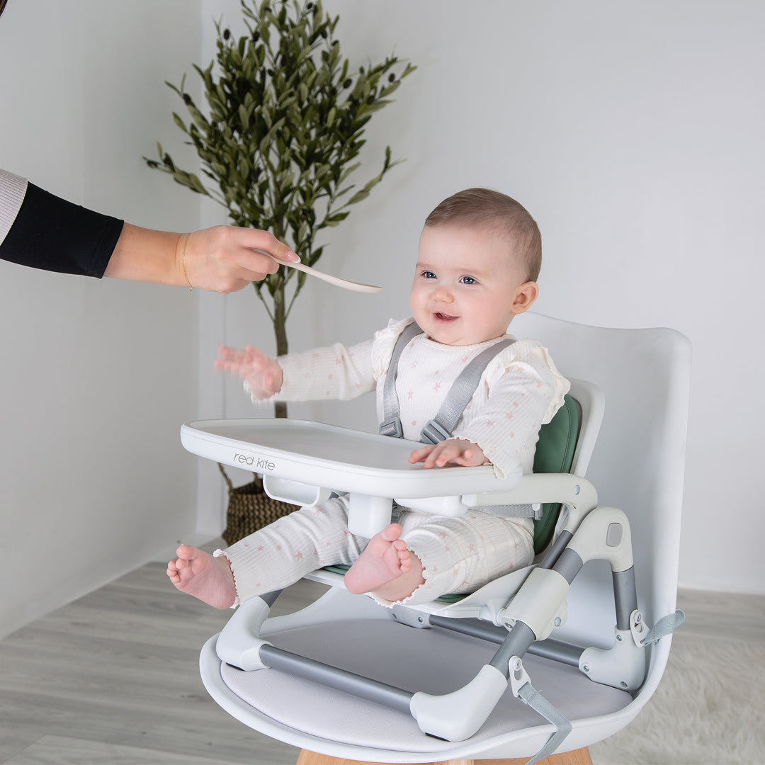Red Kite Feed Me Nom Nom Booster Seat in Sage lifestyle image attached to chair