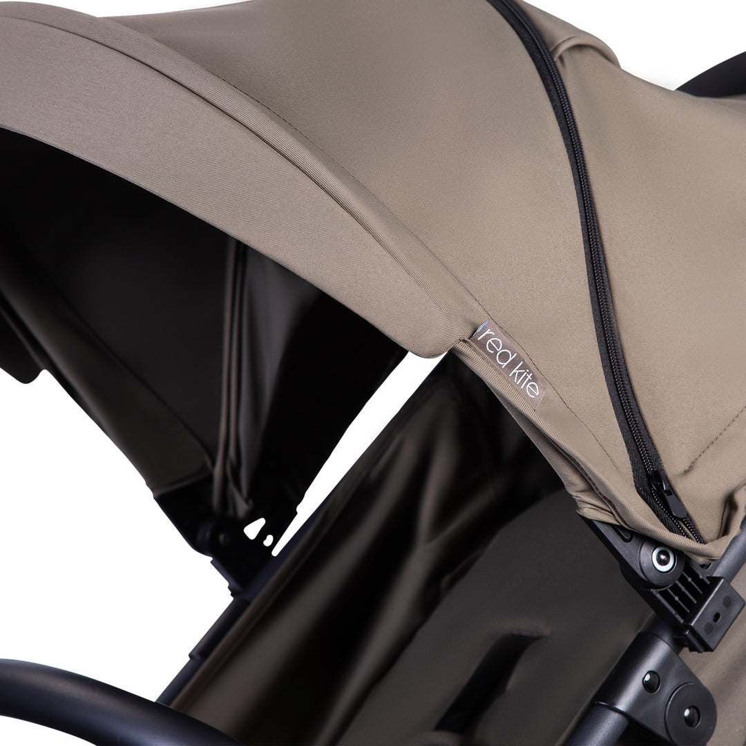 Red Kite Push Me Urbana with Close-up of a beige canopy on a stroller with 'Red Kite' branding.