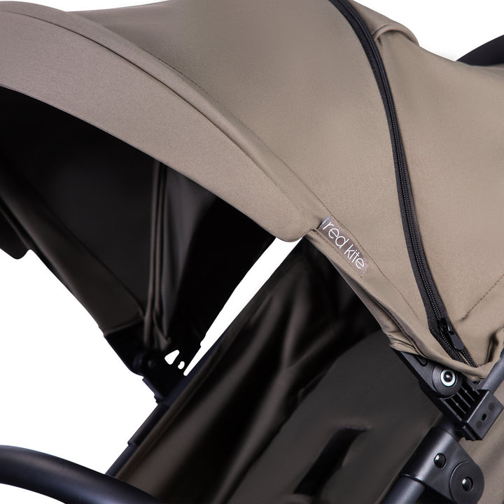 Red Kite Push Me Urbana with Close-up of a beige canopy on a stroller with 'Red Kite' branding.