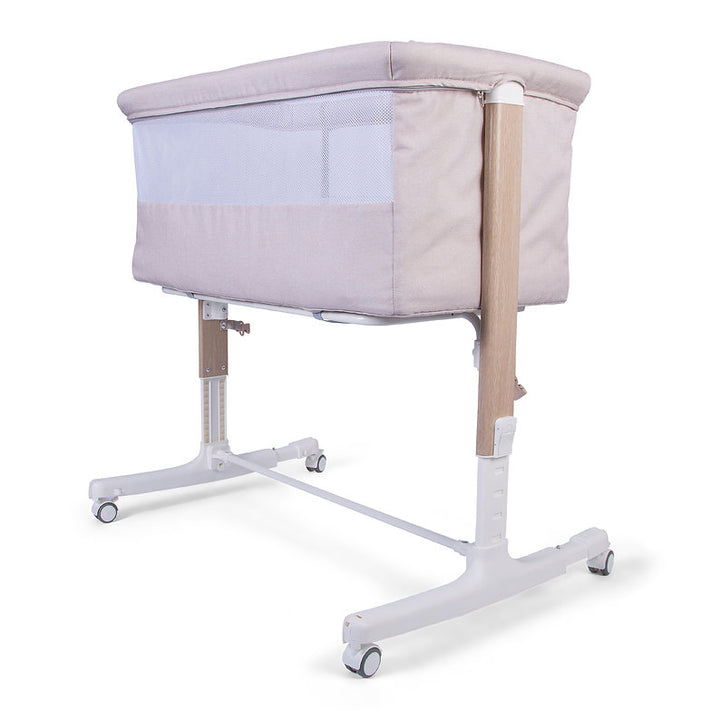 Red Kite Rockabye Bedside Crib with wheels on a white background