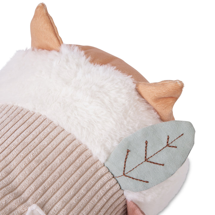Close-up of a plush toy resembling a fox with white fur, brown ears, and a textured body on a white background.